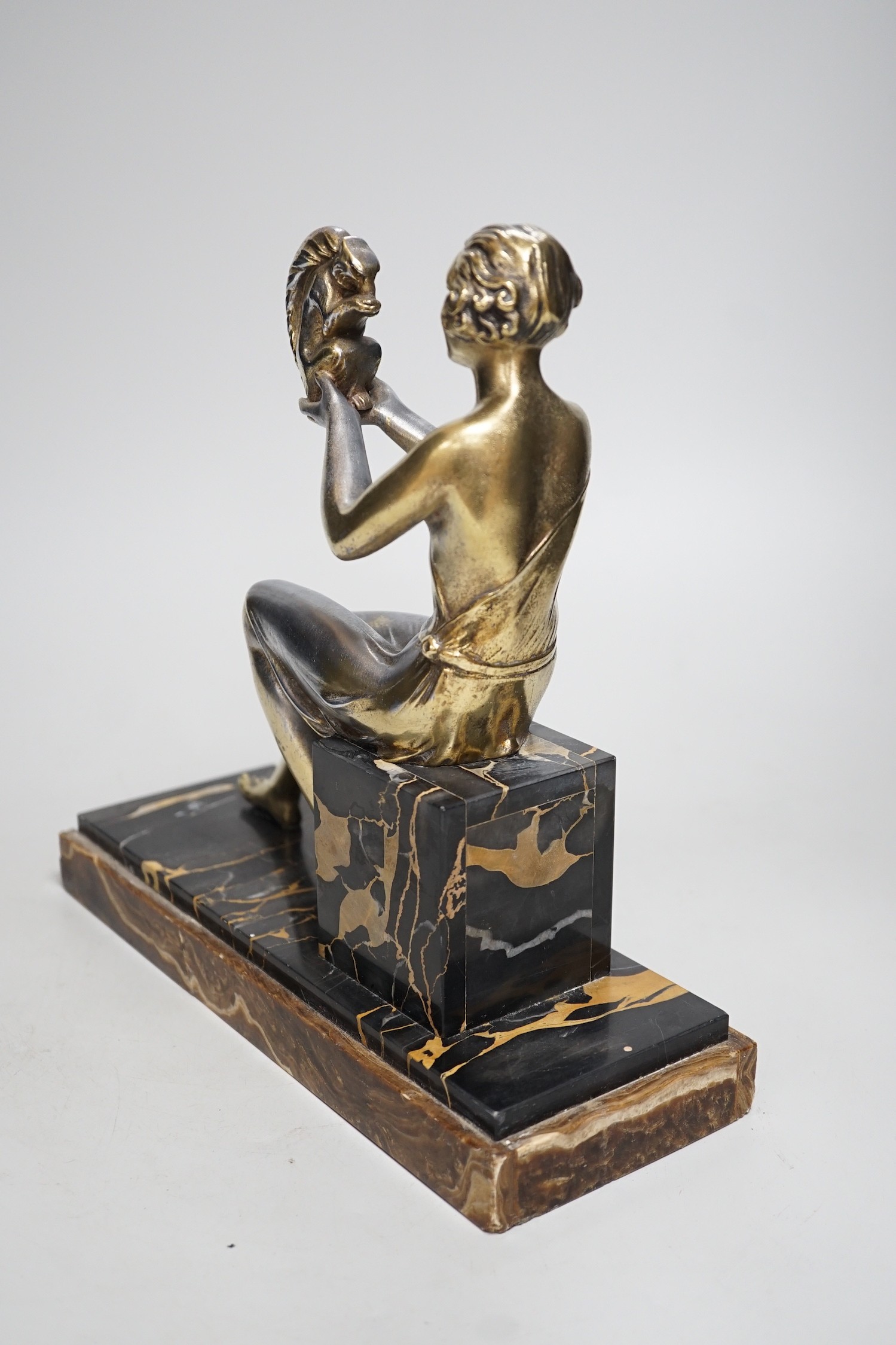 An Art Deco spelter gilded and silvered seated lady holding a squirrel, on marble and onyx mount, signed J. Dauvergne. 26cm tall